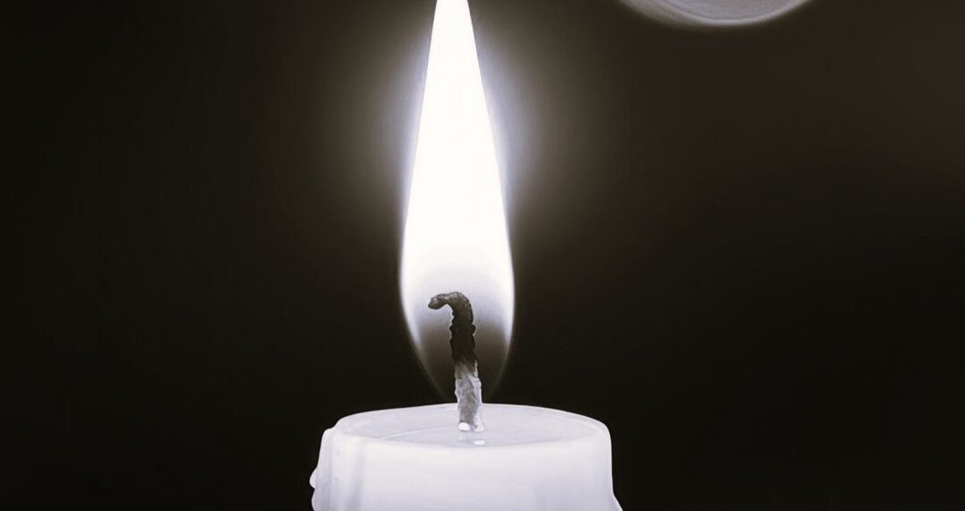 Burning candle with warm bokeh lights in the background. The soft glow of the flame creates a peaceful and intimate atmosphere, symbolizing relaxation, meditation, or remembrance.