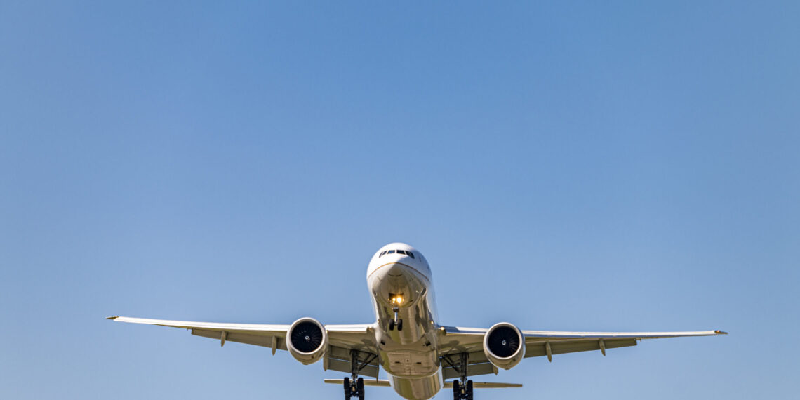 Low angle shot airplane flying closer daytime scaled