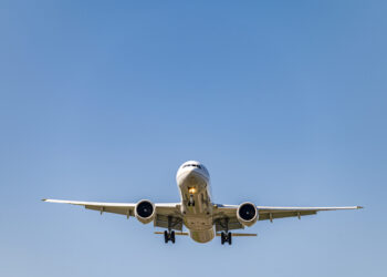 Low angle shot airplane flying closer daytime scaled